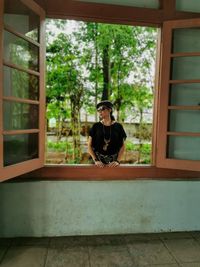 Portrait of woman sitting in window