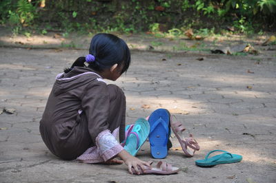 Rear view of woman sitting outdoors