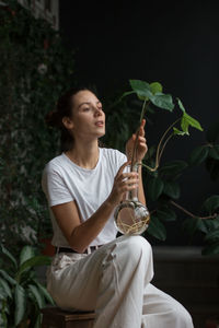 Young woman drinking drink sitting outdoors