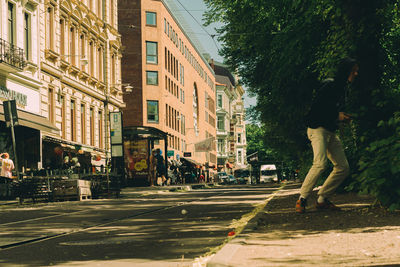 People walking on road along buildings