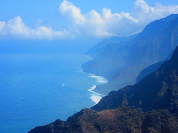 Scenic view of sea and mountains against blue sky