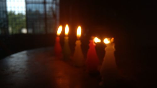 Close-up of hand on illuminated candles