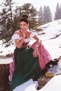 Portrait of smiling young woman standing in snow