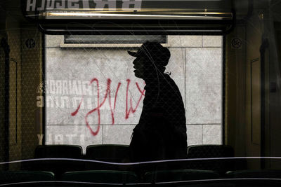 Rear view of people in graffiti on wall