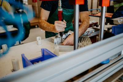 Midsection of man working at workshop