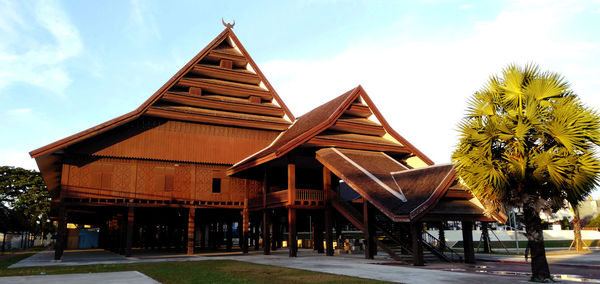 Exterior of building by palm trees against sky