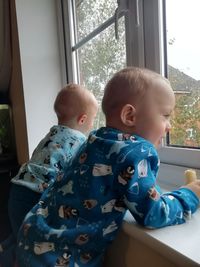 Cute boy sitting on window