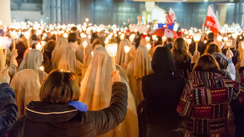 Crowd with illuminated candles in church