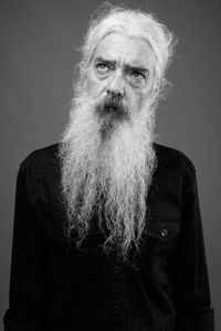 Portrait of man standing against gray background