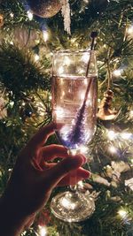 Close-up of hand holding illuminated christmas tree at night