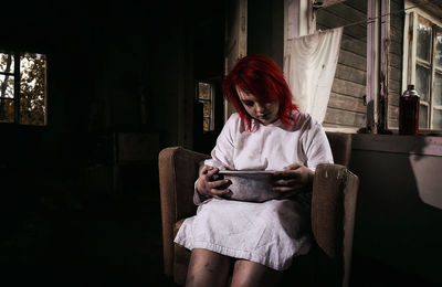Portrait of young woman sitting at home
