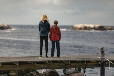 Rear view of people standing on beach