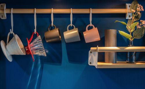 Close-up of clothes hanging on table against blue wall