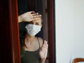 Portrait of woman standing by window