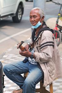 A guitarist is playing on the sidewalk