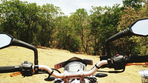 Close-up of cropped motorbike on landscape