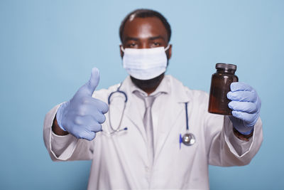 Portrait of scientist holding bottle against white background