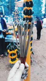 Close-up of woman holding burning incenses at market