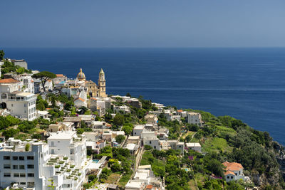 High angle view of townscape by sea against clear sky