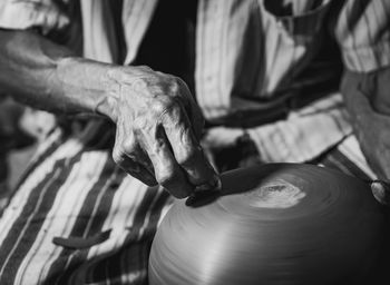 Midsection of man making pottery in workshop