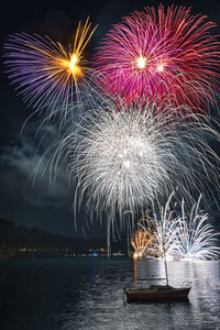 Firework display over lake at night