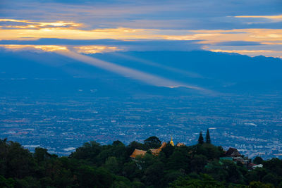 Scenic view of city and mountains against sky at sunset