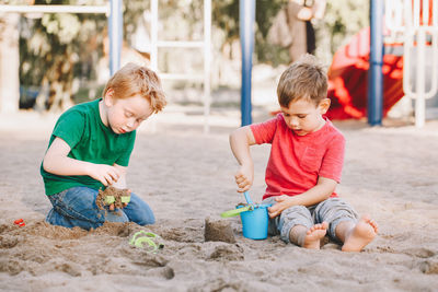 Boys playing with sand at beach