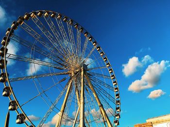 Low angle view of ferris wheel against blue sky