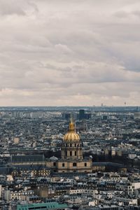 Buildings in city against cloudy sky