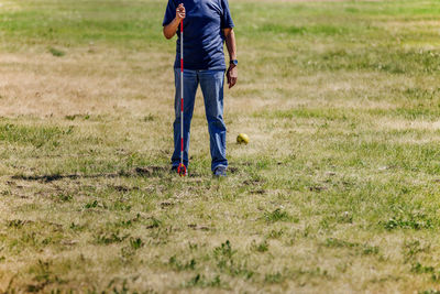 Low section of man standing on field