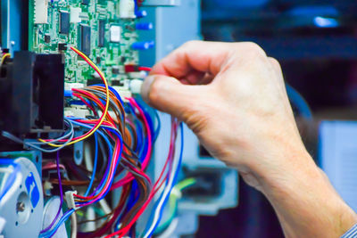 Cropped hand of man repairing electrical equipment