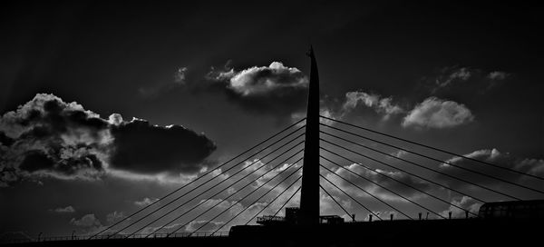 Low angle view of suspension bridge against sky