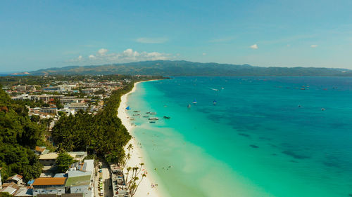 Tropical lagoon with turquoise water, sailing yachts and white sand beach from above. boracay