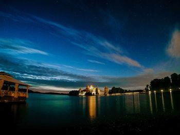 Reflection of illuminated building in water at night