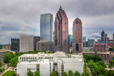 Modern buildings in city against cloudy sky