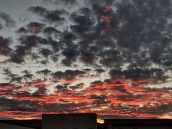 Low angle view of building against dramatic sky