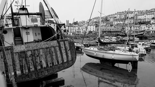 Boats moored at harbor against sky