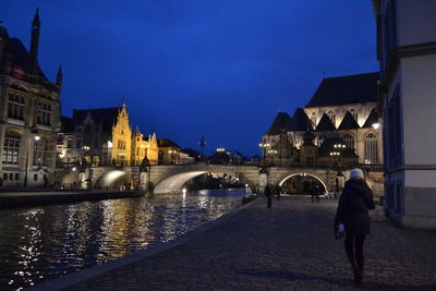 View of illuminated bridge over river at night