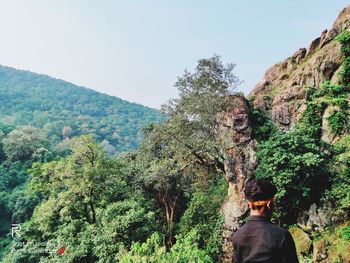 Rear view of man on mountain against sky