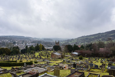 Panoramic view of cemetery and buildings against sky