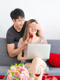 Young woman using phone while sitting on table