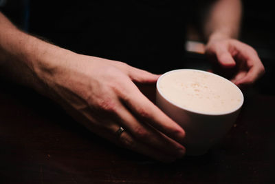 Close-up of man holding drink on table