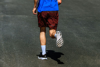 Low section of man walking on road