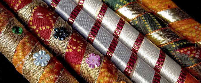 Cropped decorated dandiya sticks against black background