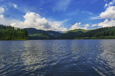 Scenic view of lake by mountains against sky