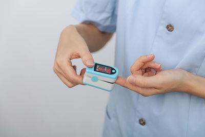 Midsection of man holding thermometer