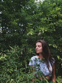 Young woman looking away in forest