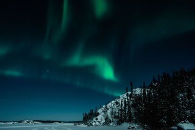 Scenic view of snowcapped mountains against sky at night