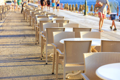 Tables and chairs arranged in row at beach