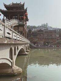 Arch bridge over river against buildings in city